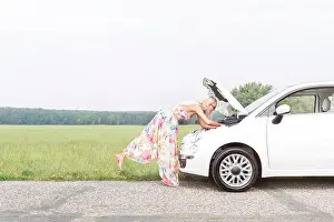 Worry Prints: Full-length side view of woman examining broken down car on country road