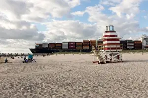 Beach Scene Prints: A fully loaded container ship sails by a lifeguard tower off South Beach