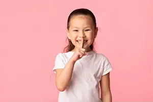 Empty Space Prints: Funny cute asian girl puting finger on lips
