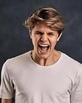 Quarrel Prints: Furious, enraged young man over gray background