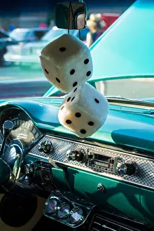 Rearview Prints: Fuzzy dice hang from the mirror of a classic car