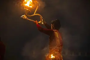 Rituals Prints: Ganga aarti, Portrait of a young male hindu priest performing holy river ganga early morning aarti at assi ghat