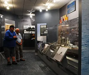 Exhibits Prints: Gary Royse (right), a volunteer docent at the Hampton Roads Naval Museum