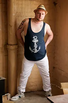Tattoos Prints: Gay man wearing white trousers and blue vest indoors