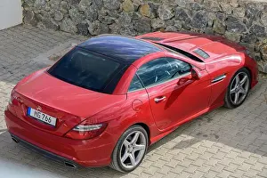 Vibrant Color Prints: Gaziveren Cyprus -10.10.2024 A sleek red sports car rests elegantly on a patterned driveway