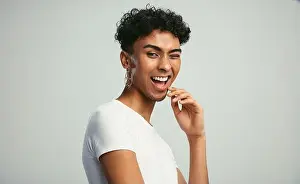 Generation Z Prints: Gender fluid man with earring winking to the camera