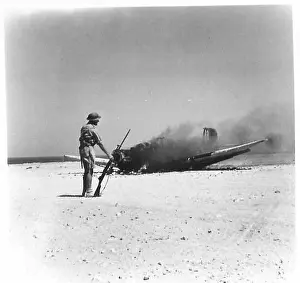 Flames Prints: A German bomber is destroyed after being struck by anti-aircraft gunfire at Tobruk