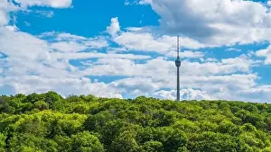 Germany, Stuttgart television tower building surrounded by endless green trees of forest on sunny day