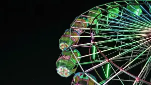 Spinning Prints: Giant ferris wheel with green lighting in An Exhibition indian Fair at night