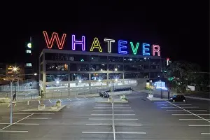 Giant neon sign reading "WHATEVER" on a building in Auckland, New Zealand, a public artwork by artist Martin Creed