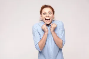 Redhead Prints: Ginger businesswoman rejoicing for his success. Isolated on light blue background