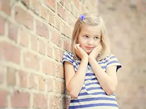 Lean Prints: Girl, 10 years, leans against a wall, shy look, Portrait, Germany
