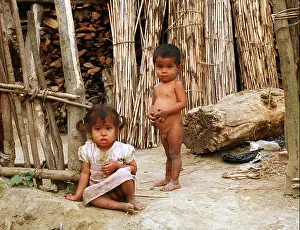 Village Life Prints: Girl and boy in front of a wood cabin in Nepal