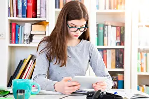Girl doing homeworks with digital tablet