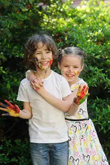 Messy Prints: Girl hugging a boy, their faces and hands in paint