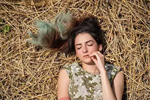 Dreaming Prints: Girl lying in a wheat field and posing on hay dry grass