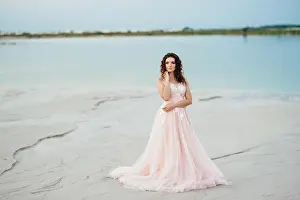 Barefoot Prints: girl in a pink dress are walking along the white sand of the desert