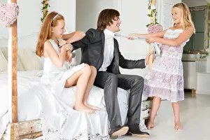 Redhead Prints: Girl pulling tie of a groom with a girl sitting beside him