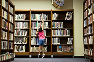 Aisle Prints: Girl reaching for book on library shelf