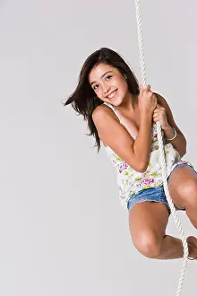 Girl wearing flower top and shorts holding from a rope, smiling, portrait