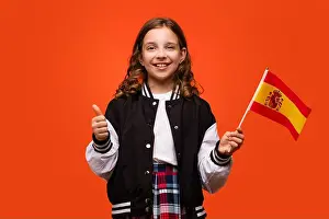 Offering Prints: Girl wearing in school outfit and holds small national flag of Spain