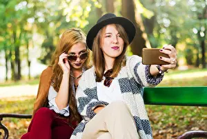 Sisters Prints: Girlfriends taking a selfie on a bench in the park