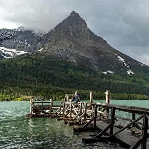 Glacier Nation park on a dock a man enjoys the warm rays of sun