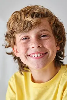 Satisfied Prints: Glad child with freckles on face skin and wavy hair looking at camera in daylight
