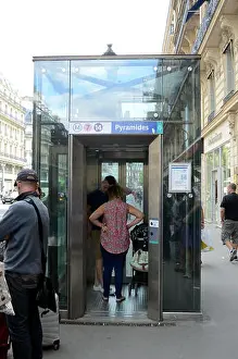 Elevator Prints: A glass elevator leads from the street down into the Paris Metro