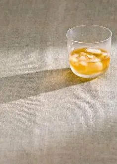 Booze Prints: Glass of whisky with ice on rough hessian cloth -