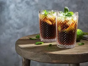 Cubes Prints: Two glasses of Cuba Libre cocktail on wooden table