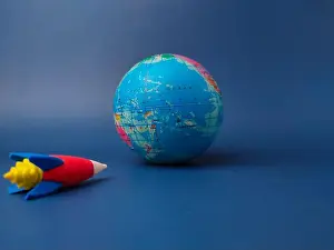 Blue Background Prints: Globe and a small red and blue toy rocket