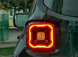 Dynamics Prints: Glowing Red Rear Light of Black Car in City Traffic – Everyday Urban Perspective