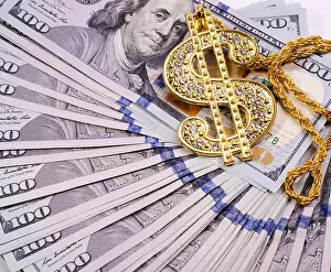 Revenue Prints: Gold Dollar Sign Necklace on a United States Dollars Banknotes