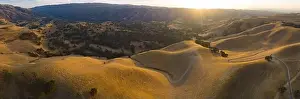 Golden sunlight shines on the rolling hills in Northern California. These beautiful, eroded hills turn green once winter brings seasonal rain