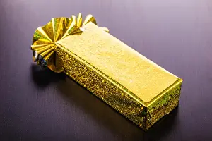 Handcrafted Prints: a golden wrapped gift box on a dark wooden surface