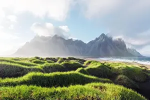 Landscape Prints: Gorgeous landscape with black sand desert dunes and grassy bumps near famous Stokksnes mountains on Vestrahorn cape