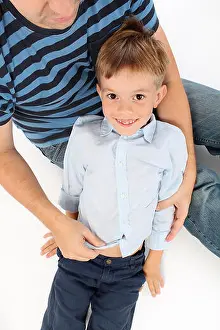 Cuddling Prints: Gorgeous little boy lying in his dad's lap getting tickled and giggling