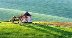 Gorgeous rural landscape with old windmill and green sunny spring hills. South Moravia region, Czech Republic