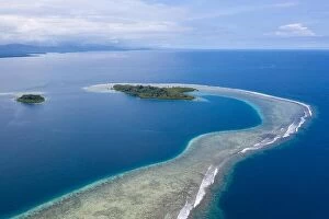 Aerial Landscape Collection: A gorgeous, tropical island is surrounded by reef in Papua New Guinea