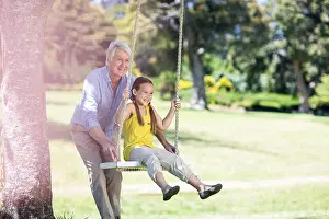 Senior Citizen Prints: Grandfather pushing his granddaughter on swing