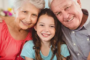 Embracing Prints: Grandparents and granddaughter sitting together on sofa