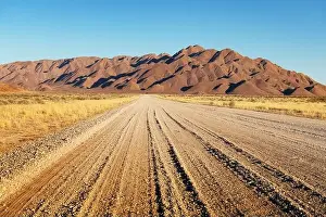 Namib Prints: Gravel road and beautiful landscape with sunset sky in Namibia, Africa