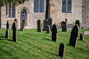 Historic Village Prints: Gravestones in the churchyard of a village parish church in England