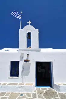 Cyclades Prints: Greek orthodox church with the Greek flag, Naoussa, Paros, Cyclades, Greece, Europe