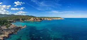 The green and rugged hilly coast of northern Ibiza with a view of the turquoise waters of Cala Xarraca bay