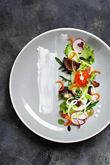Carrots Prints: Green salad with microgreens on a black plate top view