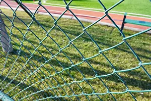 Turf Prints: Green wire fence at the football pitch close up view