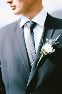 No Face Prints: Groom in a black jacket, white shirt, polka-dot tie with a boutonniere. Close up