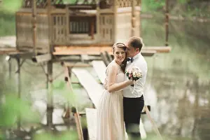 Kissing Prints: Groom kisses bride's forehead while she leans to him smiling